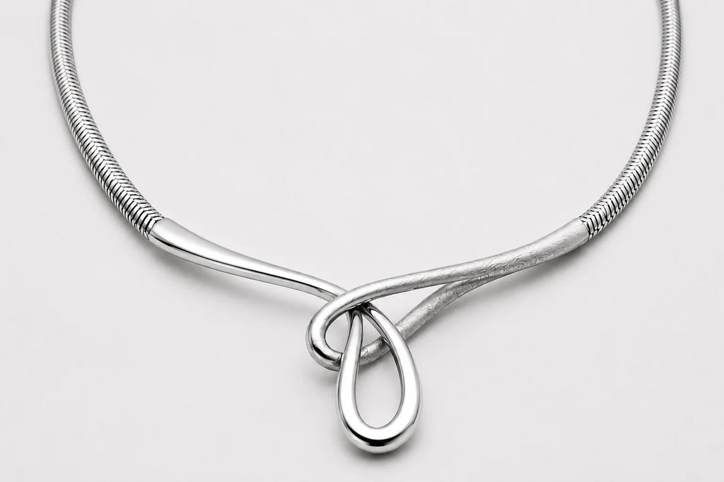 Silver necklace with a teardrop pendant on a light gray background