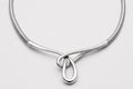 Silver necklace with a teardrop pendant on a light gray background