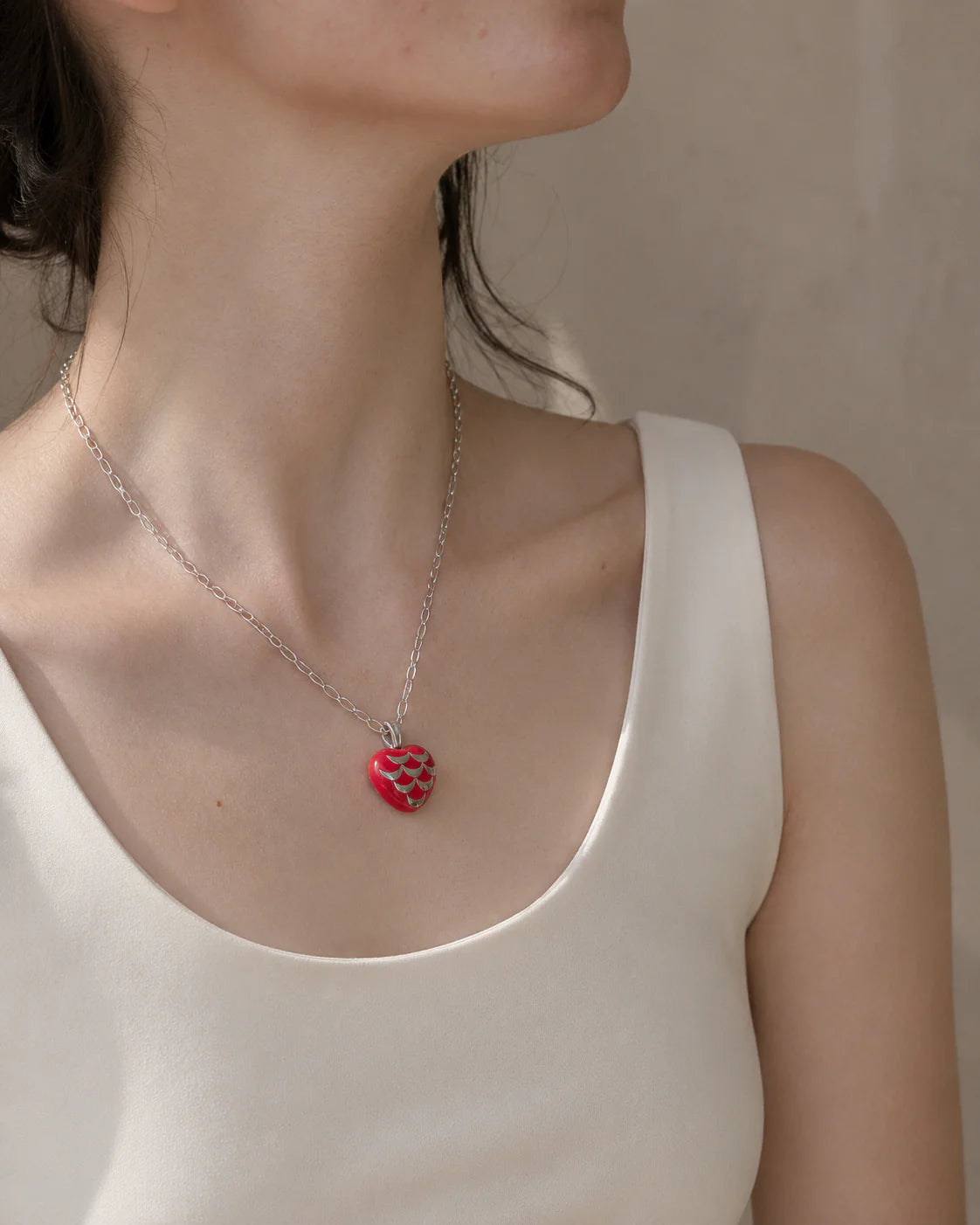 woman wearing heart shaped red pendant