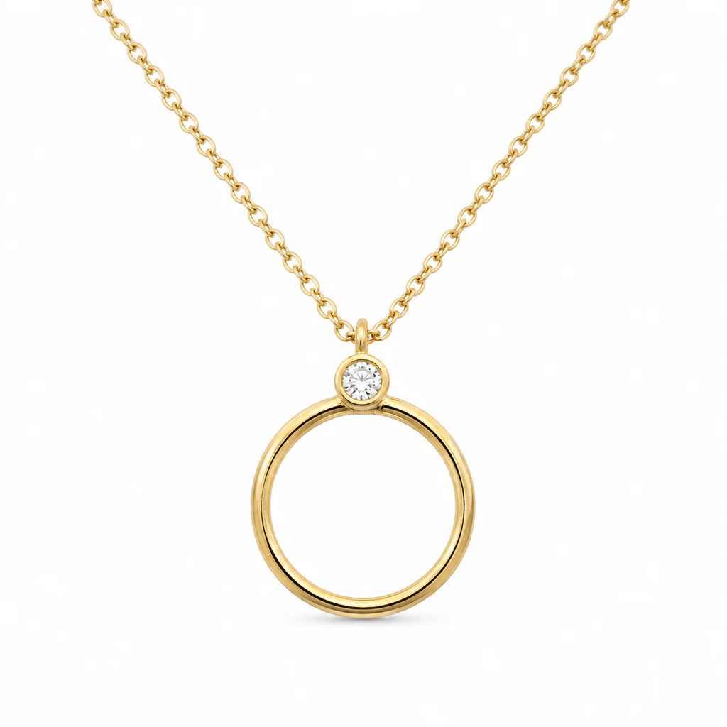 Gold necklace with a circular pendant on a white background