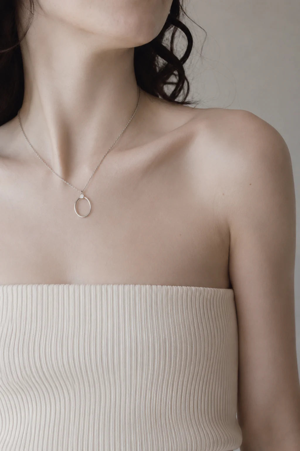Silver oval necklace worn by a woman 