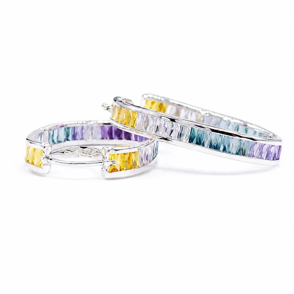 Pair of hoop earrings with multicolored gemstones on a white background