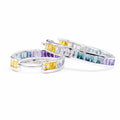 Pair of hoop earrings with multicolored gemstones on a white background