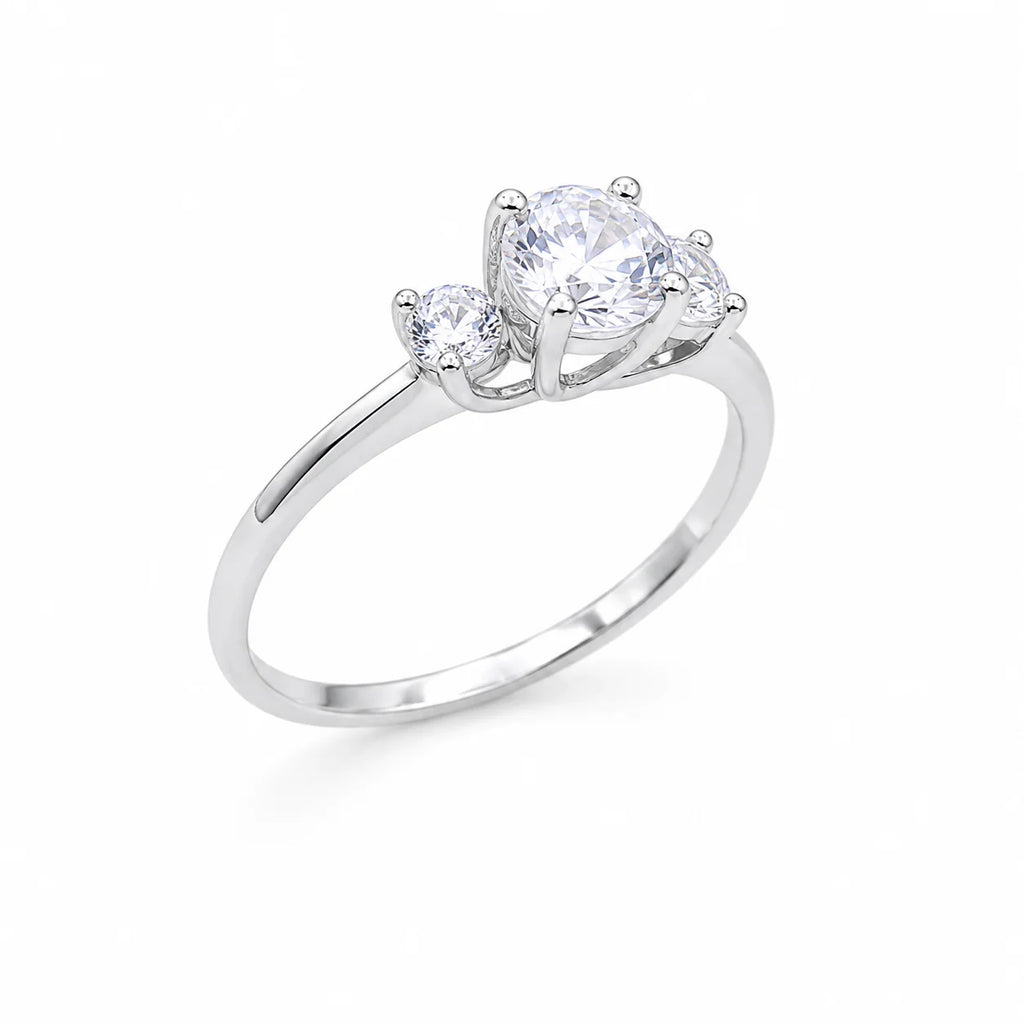 Silver ring with three clear gemstones on a white background