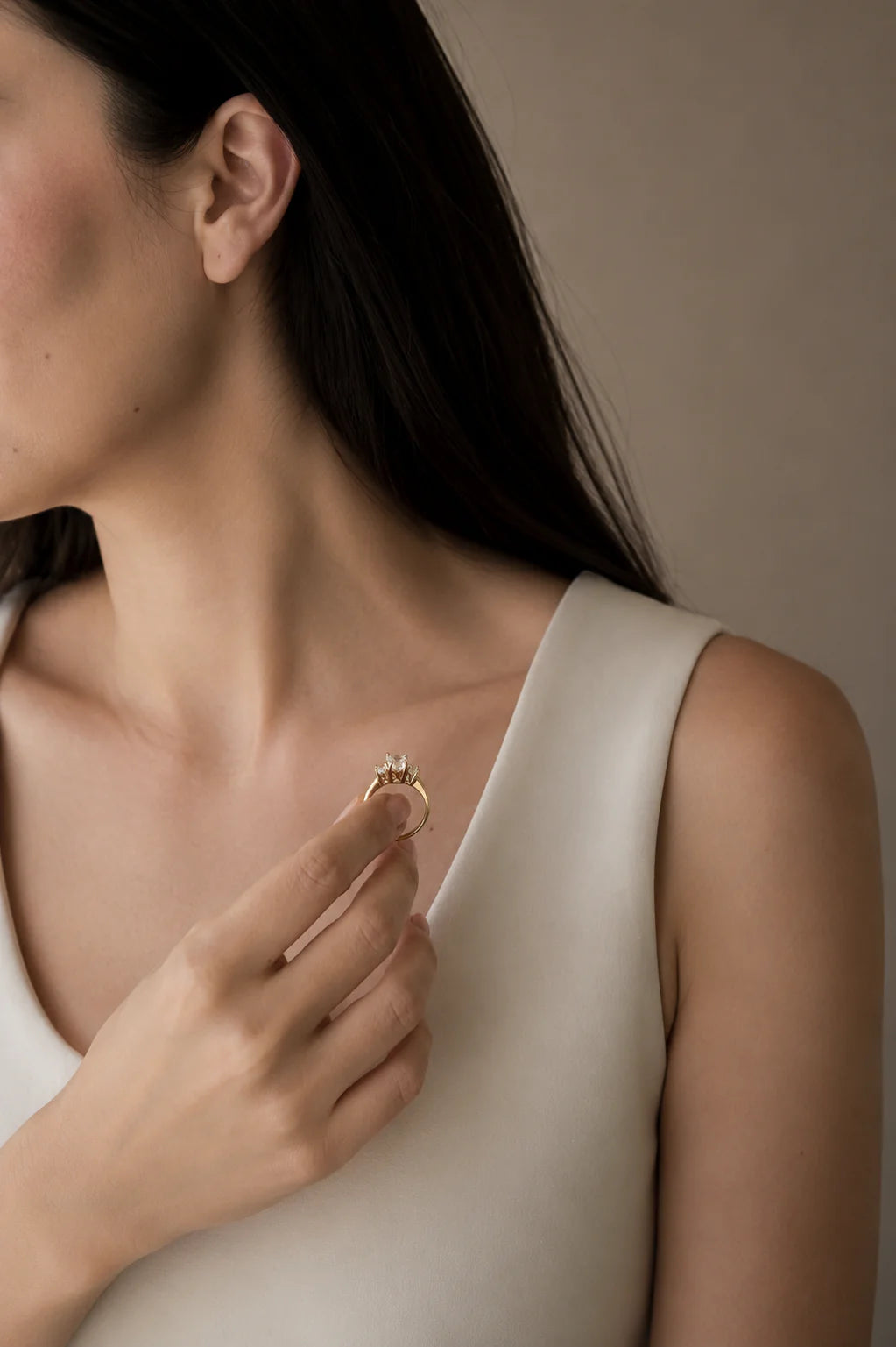 Woman wearing a gold ring on a neutral background