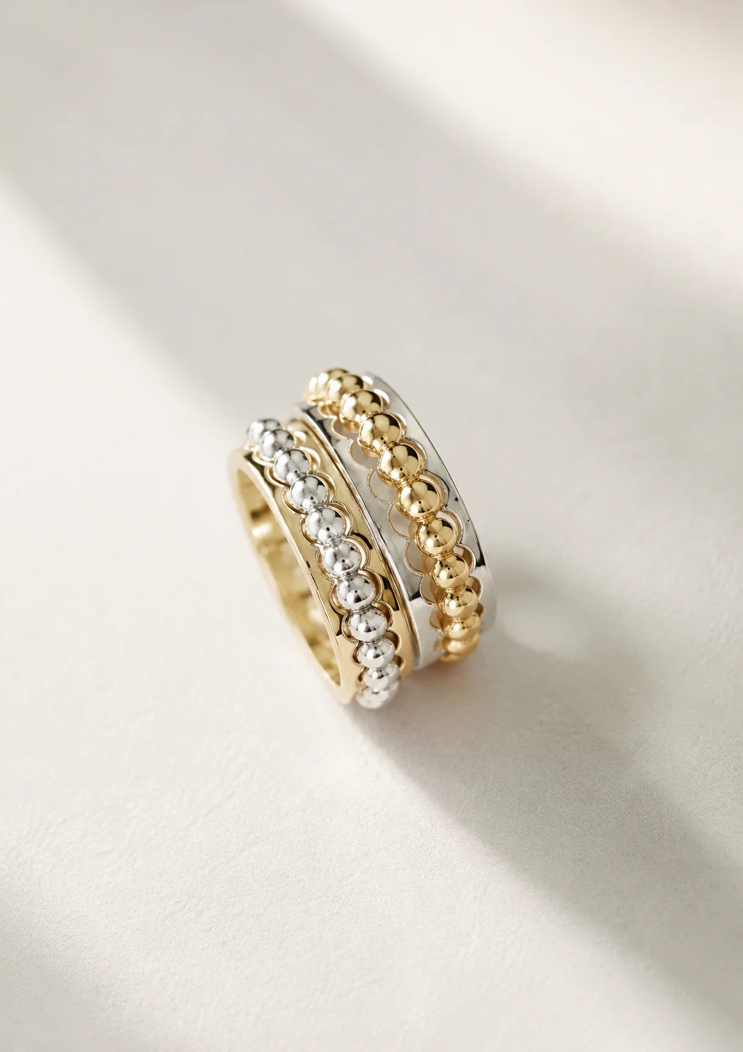 Two gold and silver rings stacked on a light background